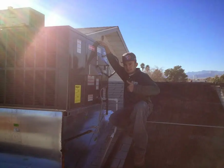 HVAC technician performing Boiler Repair on a rooftop unit in Poolesville